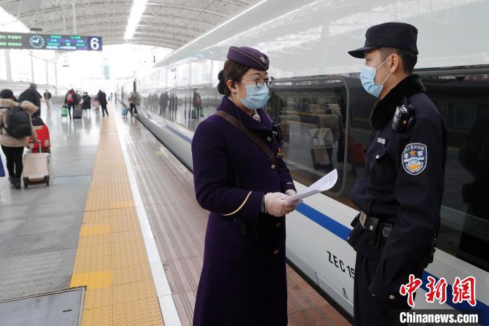 铁路上海站派出所在车站站台上与列车员交流。殷立勤 摄