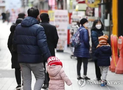 资料图：1月3日，市民走在首尔明洞。（图源：韩联社）