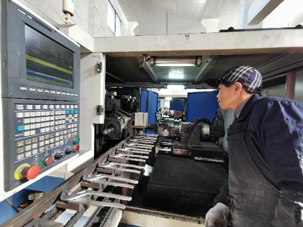 临安制钳有限公司厂区内,抛光工人正在操控数字化抛光机.