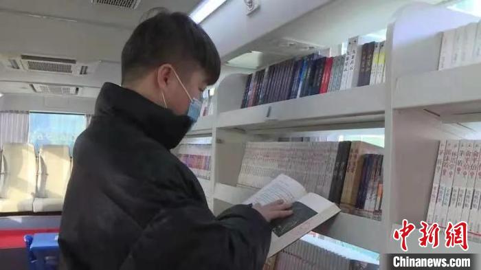 民众在流动图书车上看书. 李奔 摄