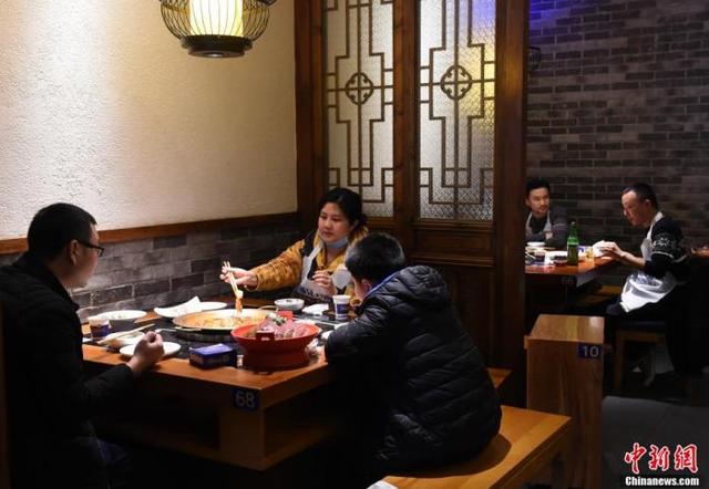 资料图：两桌吃火锅的客人用屏风分隔。 周毅 摄