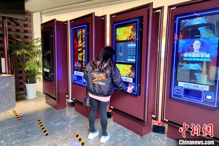 图为民众正在自助机前取电影票. 梅镱泷 摄
