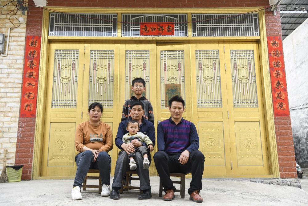 韦寒贵（右）一家与父亲一起在家门口合影（2月3日摄）。新华社记者 曹祎铭 摄