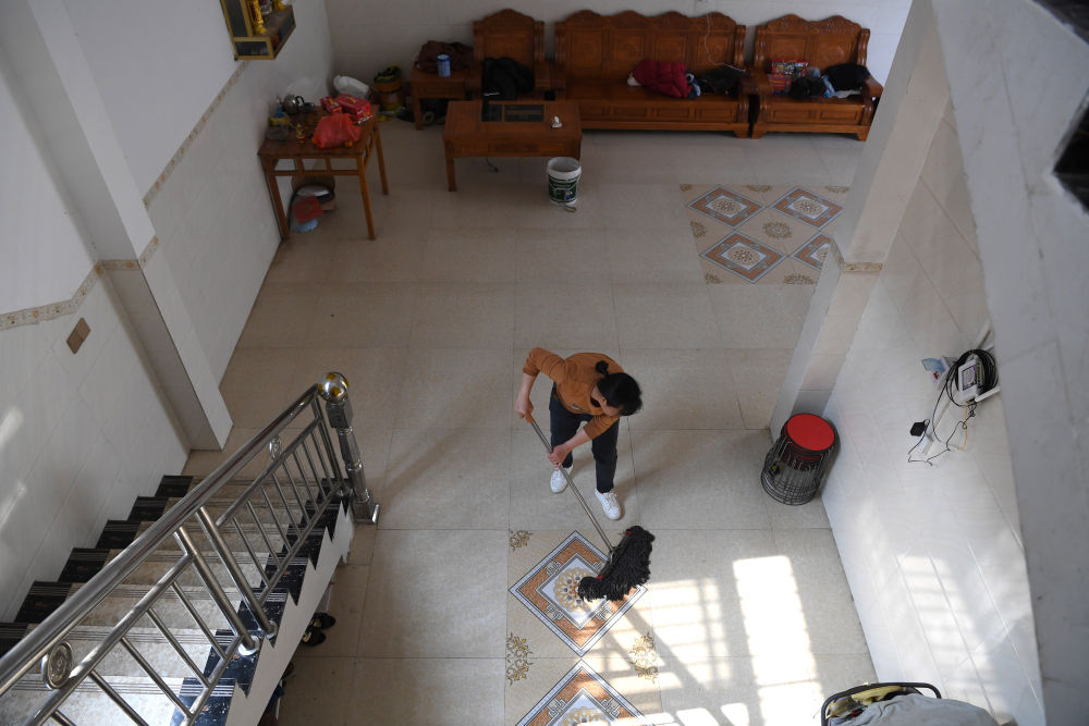 韦丽妹在打扫自家客厅（2月3日摄）。新华社记者 周华 摄