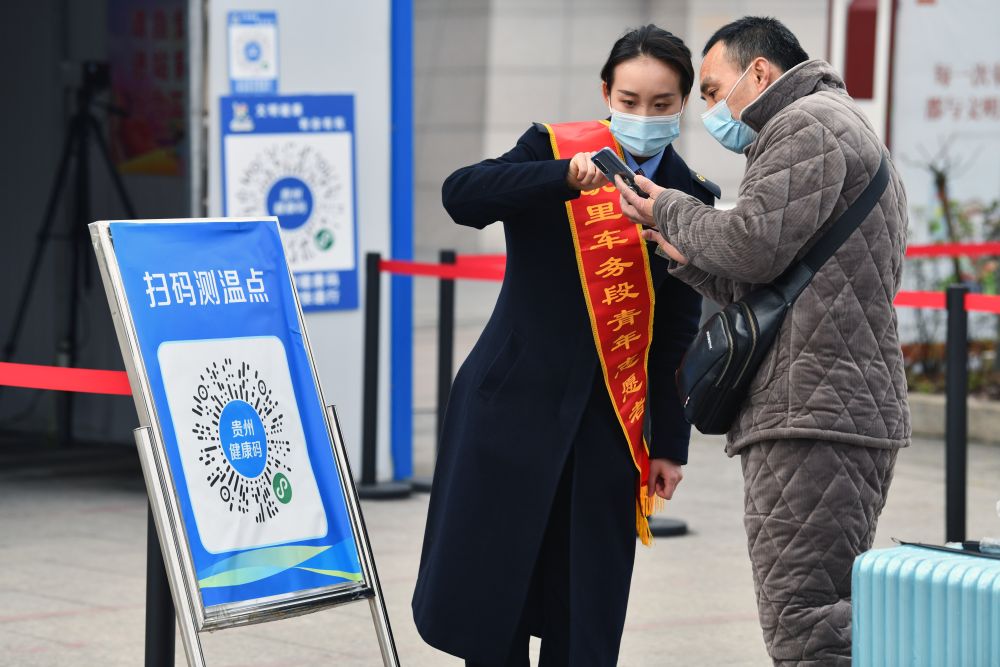 ↑1月28日，贵州省凯里南高铁站的青年志愿者在指导乘客用手机扫描健康码进站乘车。新华社记者 杨文斌 摄