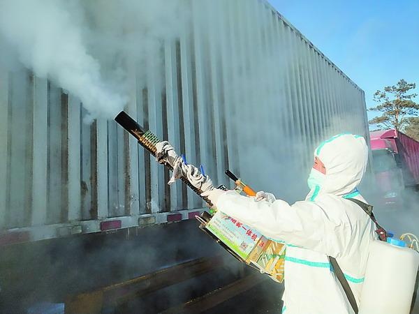 工作人员对过往货运车辆进行消杀