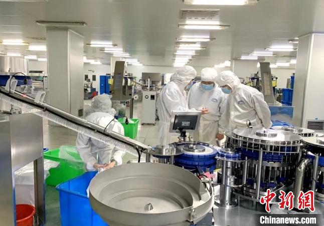 位于浙江玉环的浙江康康医疗器械有限公司生产车间里，工人们身着防护服，在调试机器、生产、搬运……　吴晓红 摄