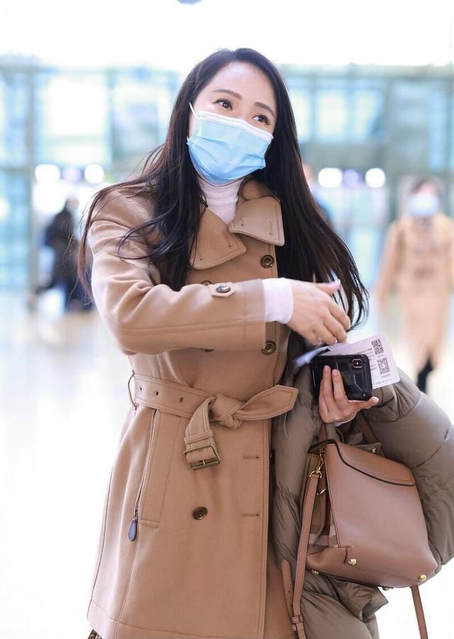 伊能静气质端庄大方穿一袭大衣内搭印花连衣裙走机场高级减龄