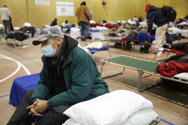 气候变化导致美国得克萨斯州近期遭遇罕见的寒潮天气，多地断电断水。图为得克萨斯当地民众2月18日在一处避难所过夜。（路透社）