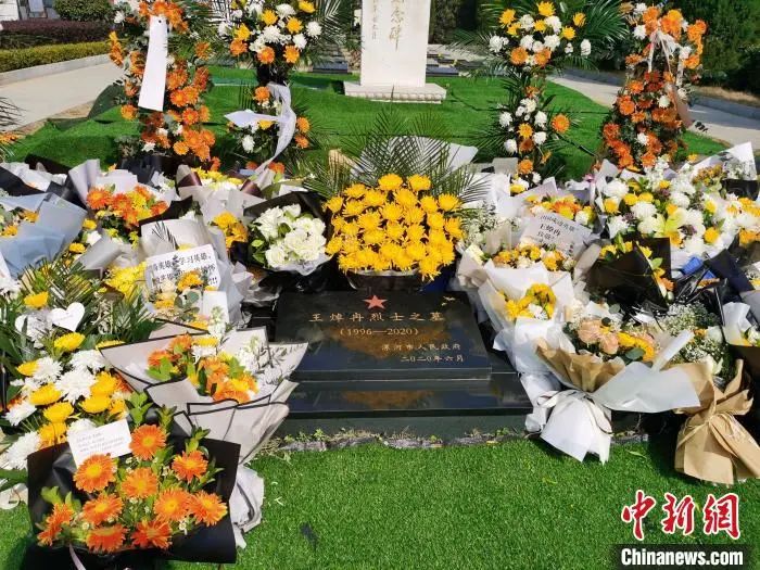 烈士王焯冉的墓碑旁边放满了鲜花。王登峰 摄