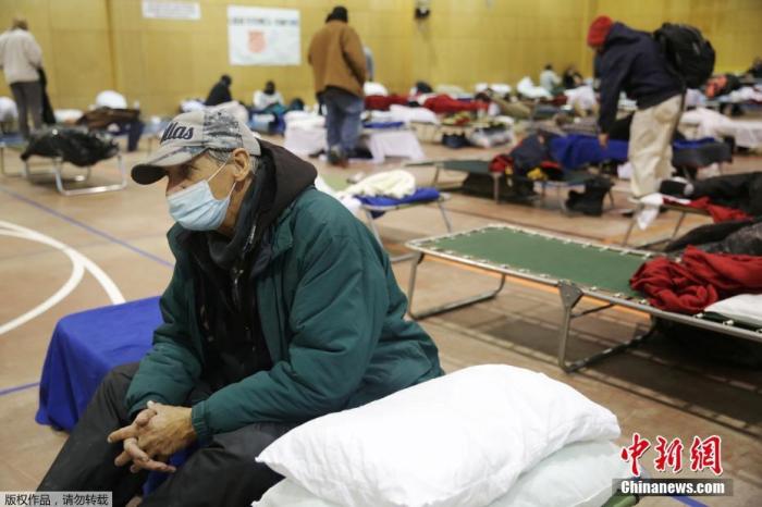 资料图：当地时间2月18日，美国得克萨斯州普莱诺因冬季天气导致停电后，人们在避难所里休息。