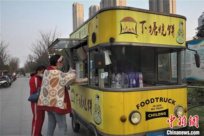 地铁口边停着"无声下塘烧饼"的黄色餐车. 张俊 摄
