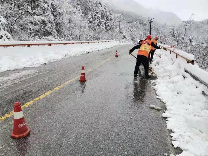 养护人员清理210国道山区段路面的积雪。图片来源：西安发布