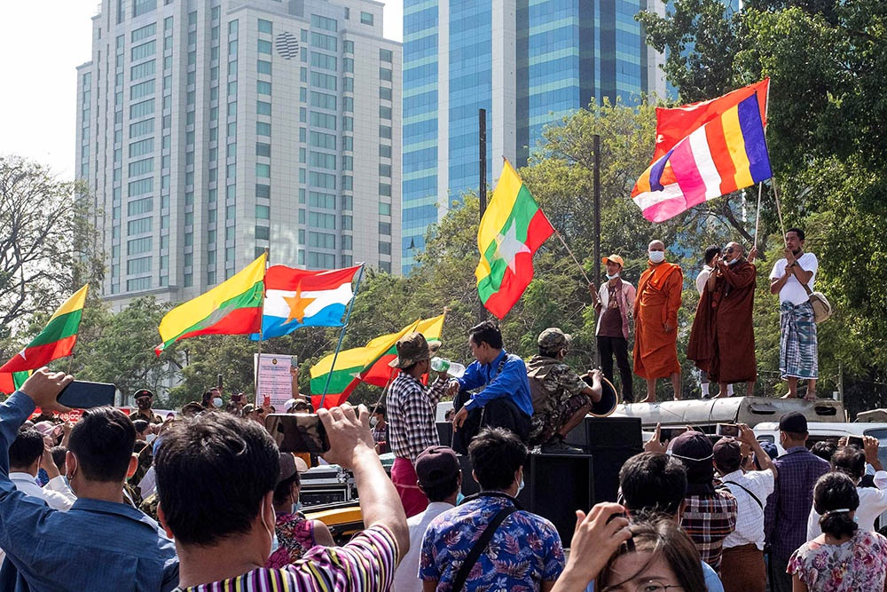当地时间2021年2月1日，缅甸仰光，军队支持者们手举旗帜在城市街道上。