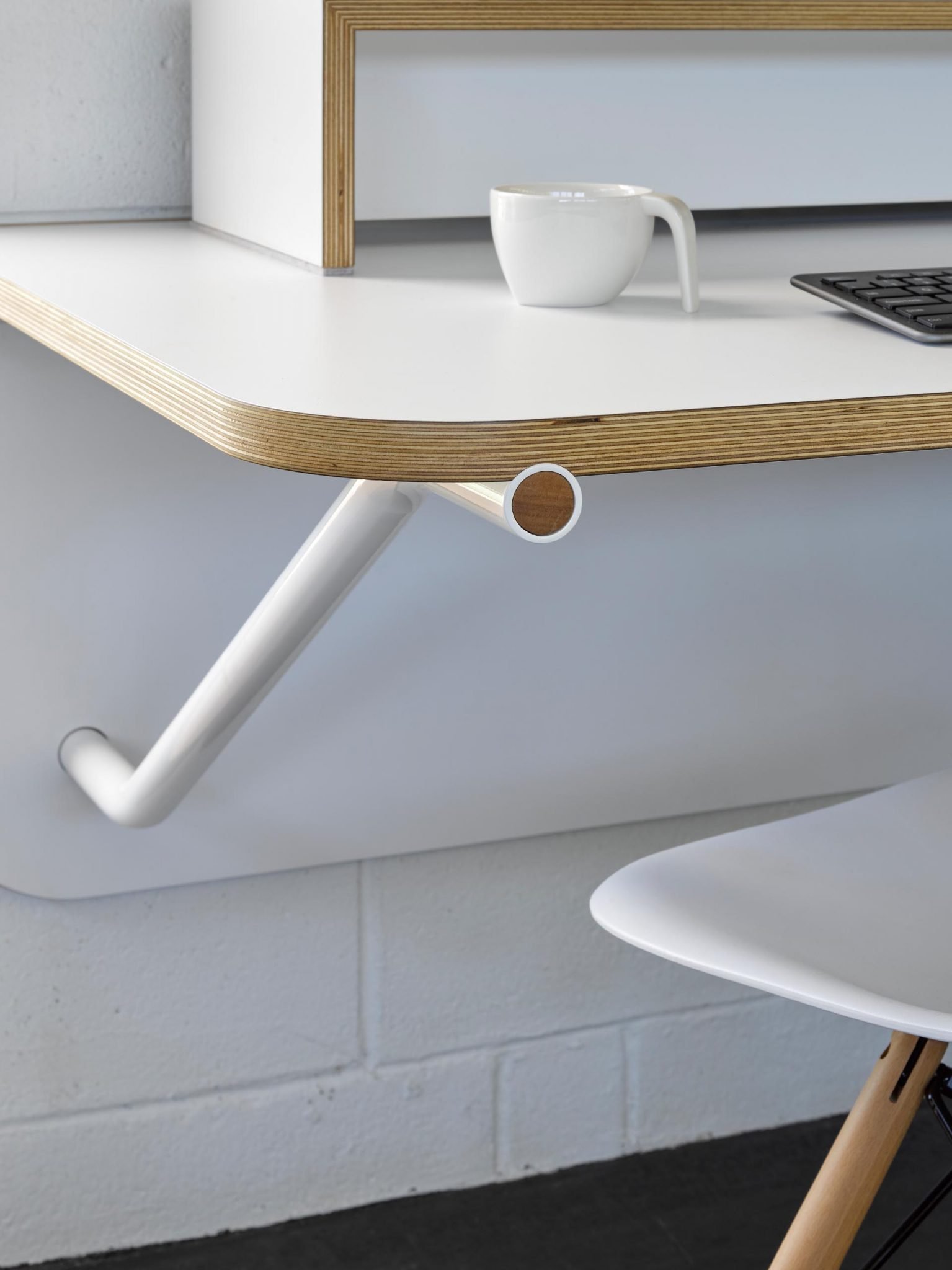 办公桌的细节处理,白色的桌子带有木质边缘,靠墙壁排成一行,并为