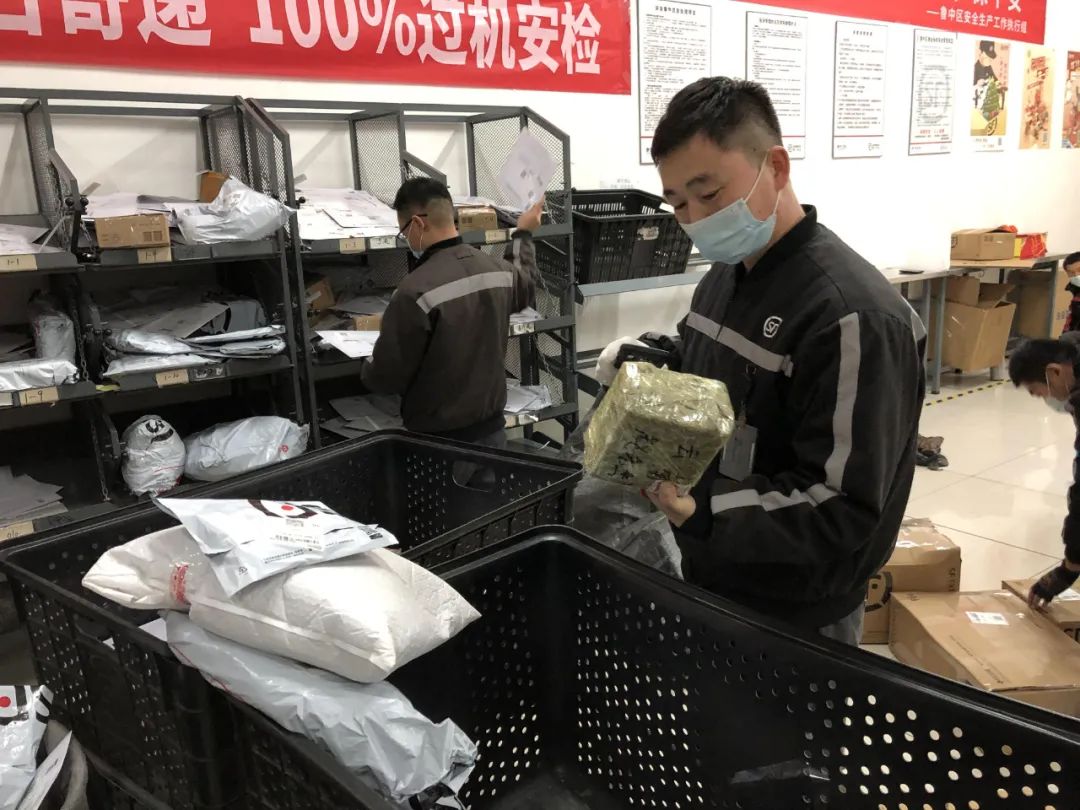 顺丰速运网点内,快递人员忙着分拣快件.