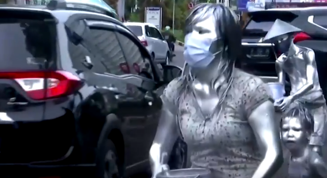 像这名妇女这样浑身涂满银色涂料的人被称为"manusia silver"或"银色