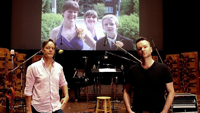 作曲家杰克·赫吉和男中音约书亚·霍普金斯在《天行者之声》的配乐舞台，背景是霍普金斯的妹妹纳萨莉·沃摩黛姆的照片。图片来源：Zoe Tarshis