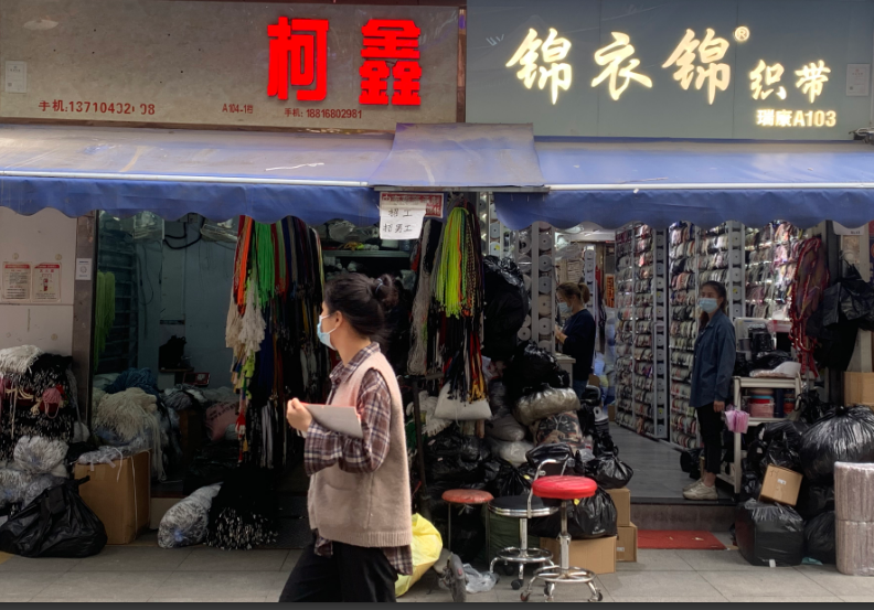 广州中大布匹市场内,许多服装店,布料店等门外挂出牌子招工人.