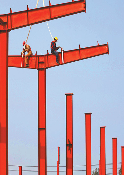 3月16日,浙江省温岭市东浦砖厂,工人在安装钢结构厂房顶梁.