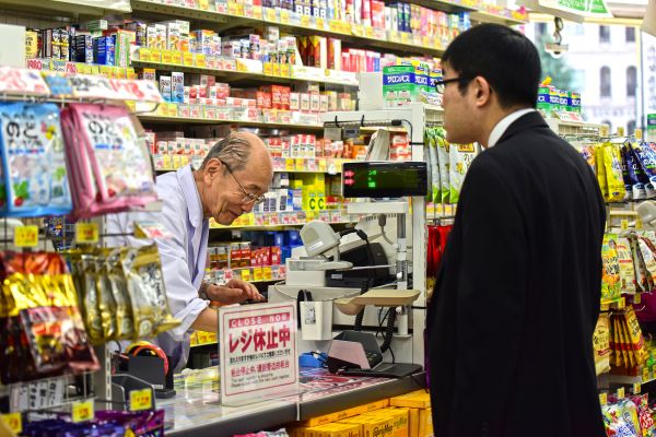 日本东京涩谷区一家药妆店内,一位老年工作者正在为顾客服务。(视觉中国)