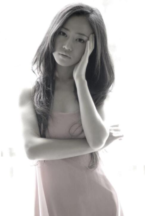 "照片中,谭卓一头公主切长发,身穿粉色吊带裙,面庞青涩,妆容素雅,甜美