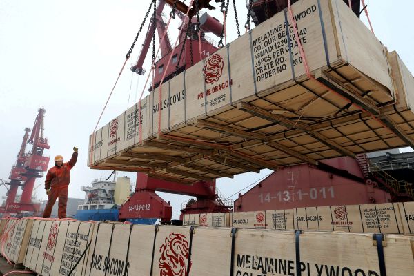工人在江苏连云港码头指挥货箱装船。（香港《南华早报》网站）