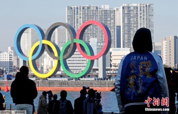 材料图;日本东京民众瞭望东京湾上的奥运五环标志、