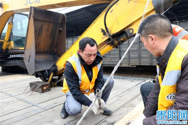 装卸工人使用绞棍对"救援挖掘机"牵引绳加固该段加大站内路基,防洪点
