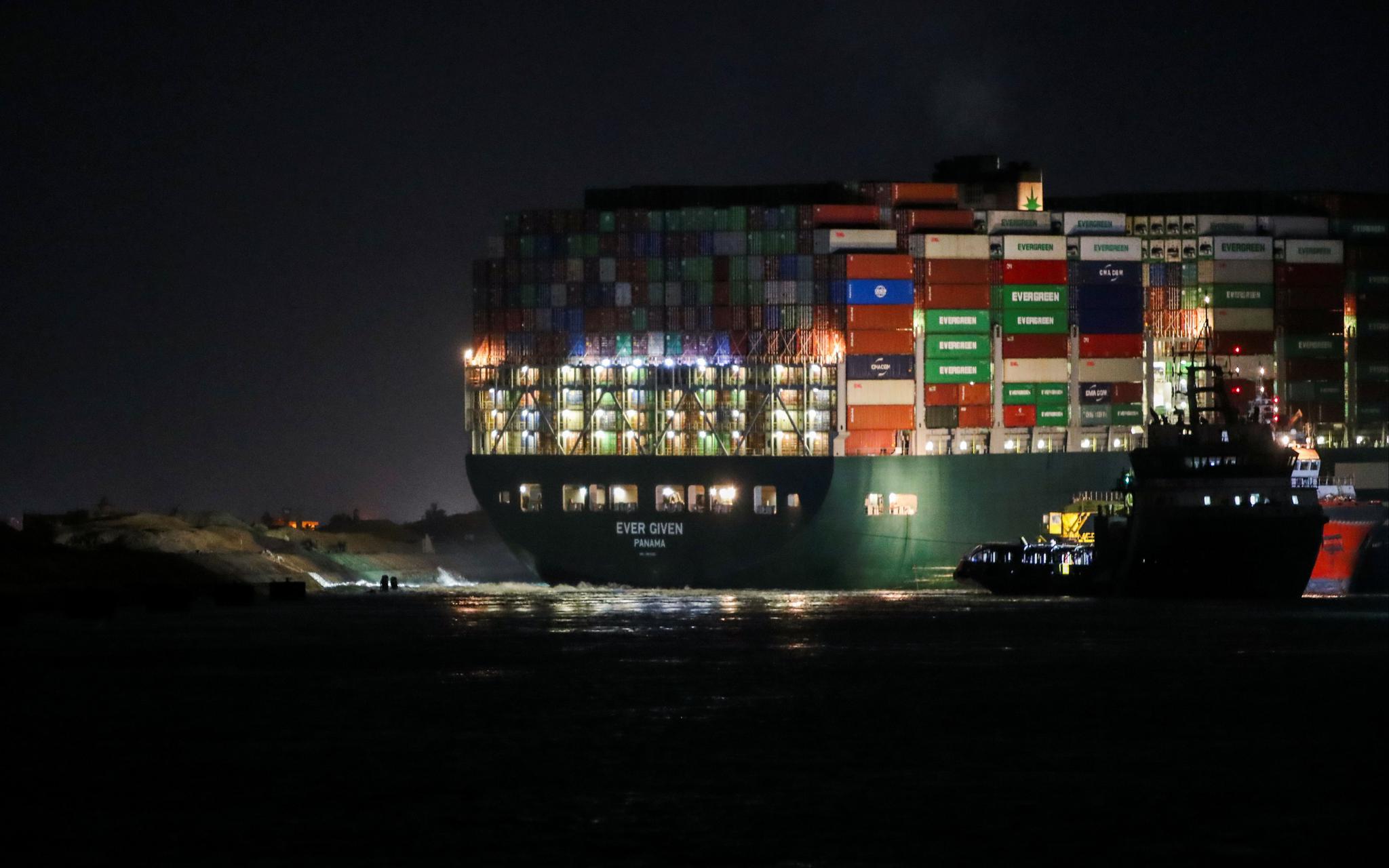 当地时间2021年3月27日，埃及苏伊士运河，夜里搁浅的集装箱船长赐号灯火通明。长赐号是世界上最大的集装箱船之一，于3月23日起在苏伊士运河搁浅，目前脱困时间尚不确定。  图/IC photo