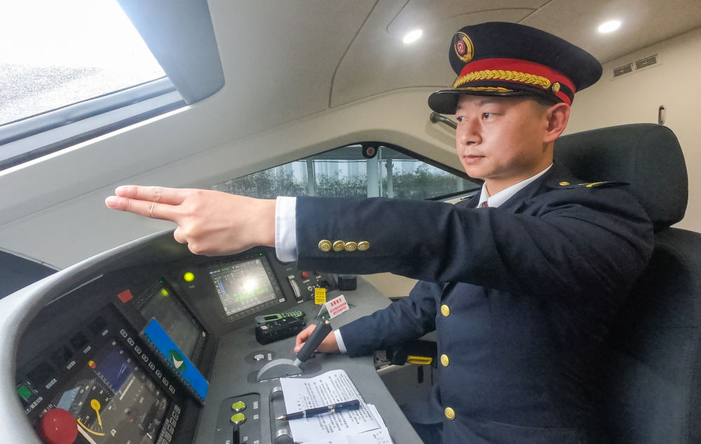 “80后”火车司机丁志中在驾驶动车（2020年12月28日摄）。新华社发（江晓 摄）