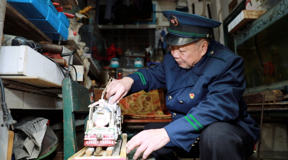 今年80岁的退休火车司机曹之耀和他雕刻的火车模型（3月12日摄）。新华社记者 梁舜 摄
