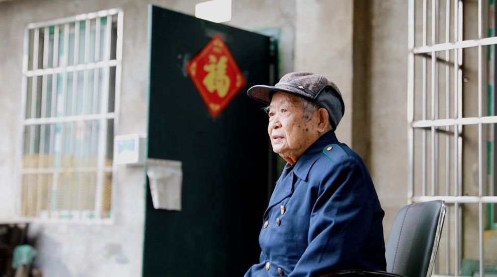今年100岁的退休火车司机任忠德在自家门前（3月12日摄）。新华社记者 覃广华 摄