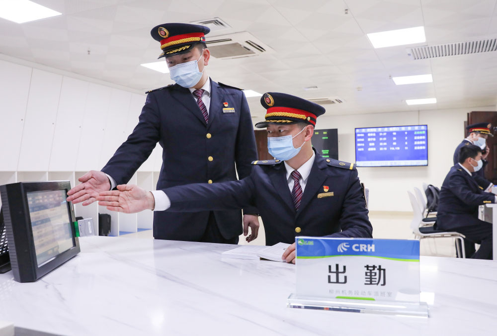 今年42岁的火车司机林斌（左）和徒弟丁志中在值班时共同确认监控数据（2月3日摄）。新华社发（江晓 摄）