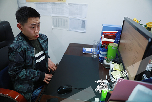 杨栩使用电脑整理数据.华龙网-新重庆客户端 谢鹏 摄