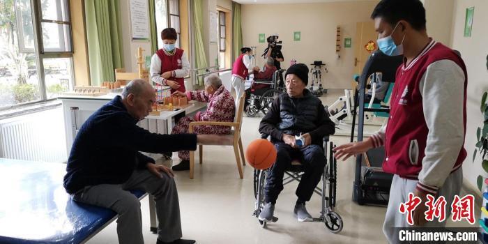 资料图:护工正在和老年人进行康复训练。 贵州省民政厅供图