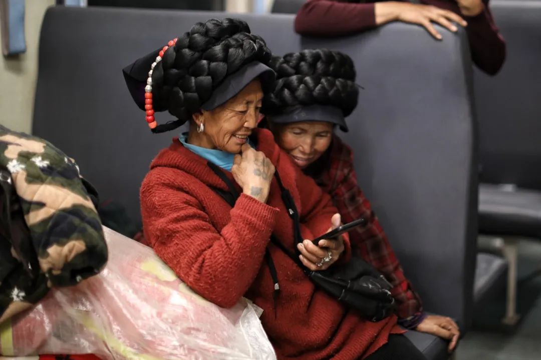  2月26日，5634次列车上的彝族乘客在用手机看短视频。新京报记者 王嘉宁 摄