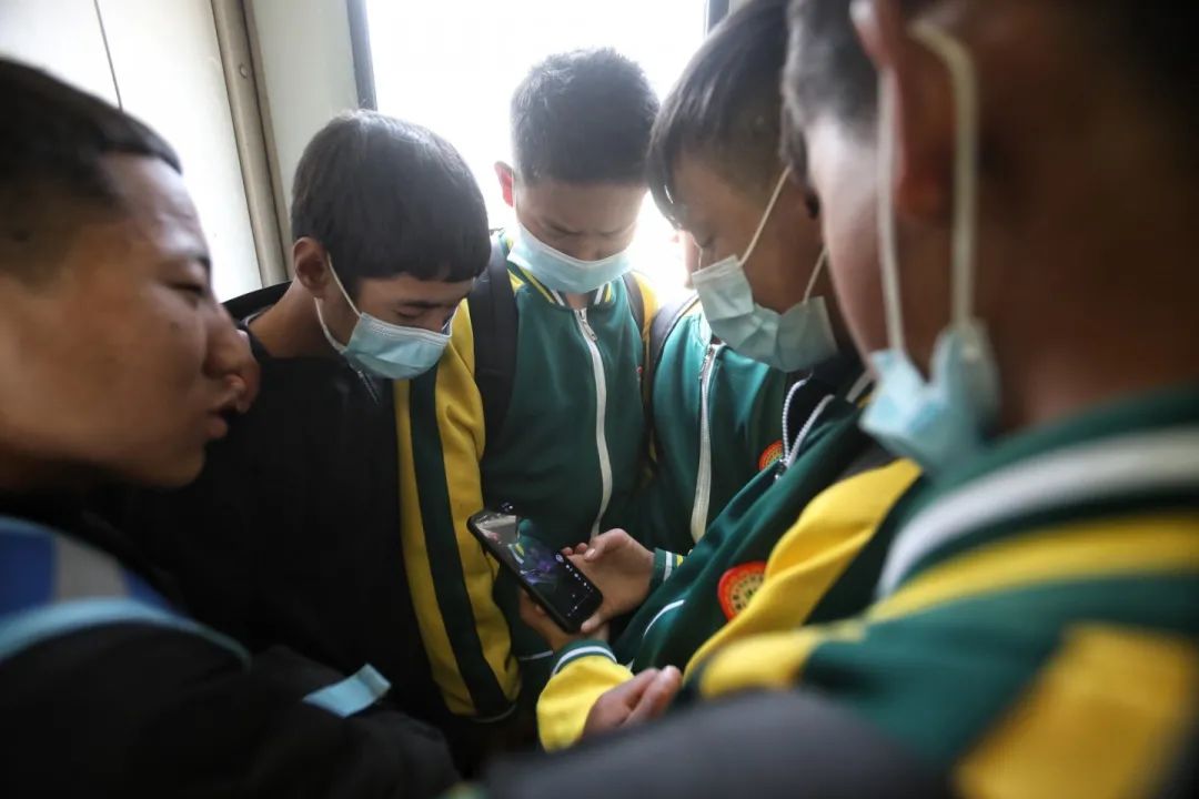 2月27日，5633次列车上，学生们看手机视频，每周末，大量学生客流通过5633/5634次列车往返学校和家。新京报记者 王嘉宁 摄