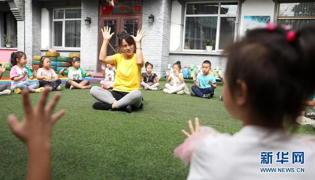 幼教老师在辽宁省凤城市大梨树村萌芽幼儿园里带领孩子们游戏(2020年9月9日摄)。新华社记者 姚剑锋 摄