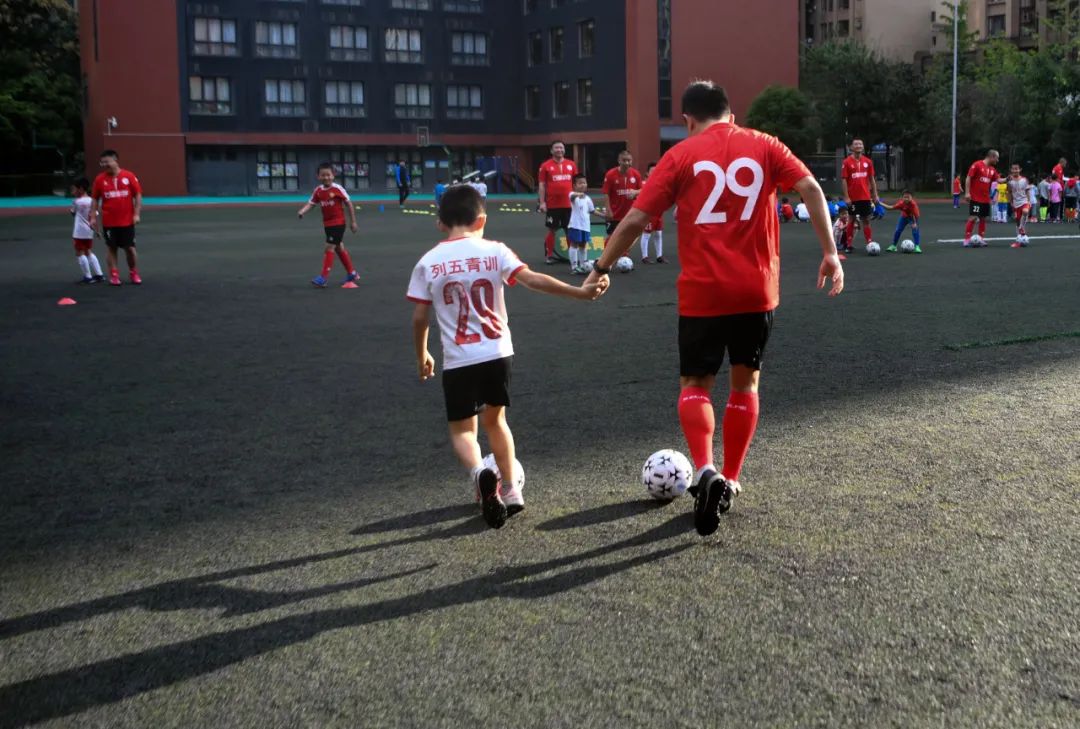 在成都石室小学，张策棋和爸爸张关强（右）在足球课上进行“携手带球前进”练习。新华社记者 唐文豪 摄