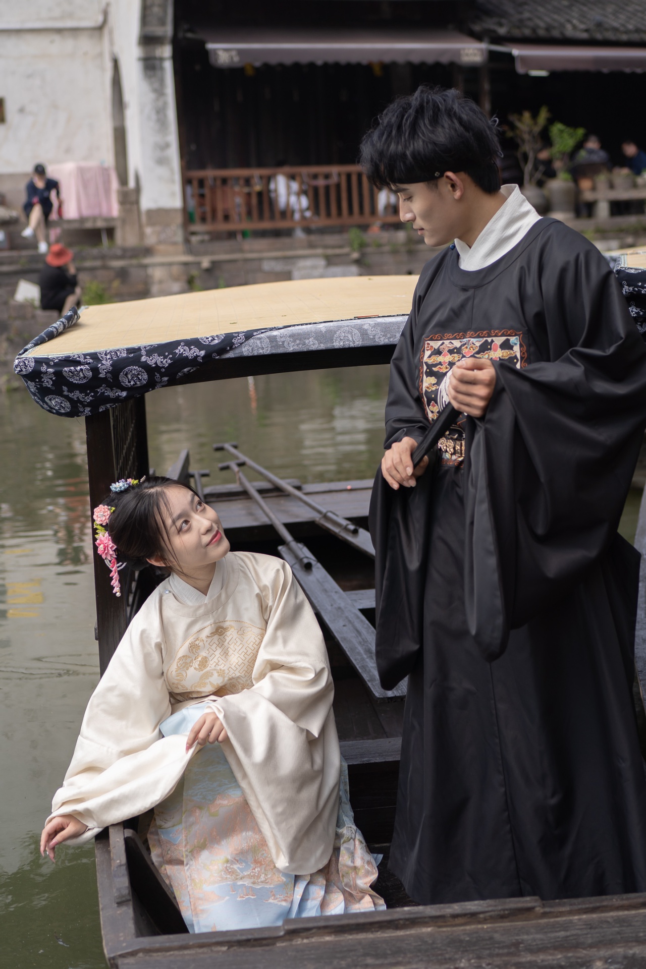 古镇入口处,蚕娘娘不倒翁翩翩起舞,吸引现场不少游客围观.