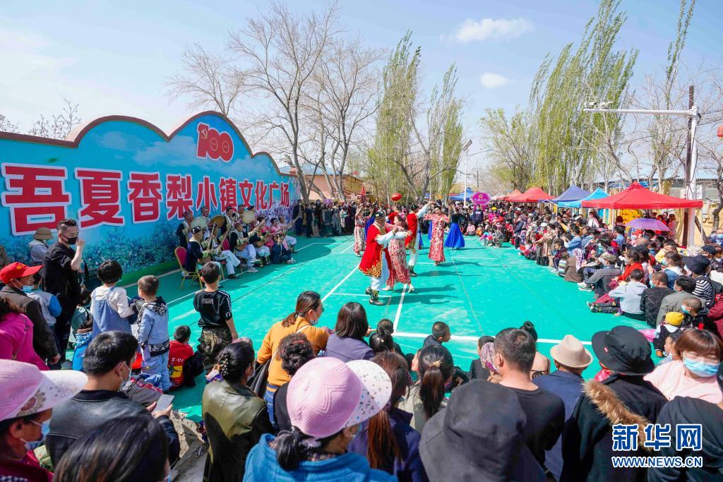 4月10日,游客在新疆库尔勒市阿瓦提乡欣赏舞蹈表演.