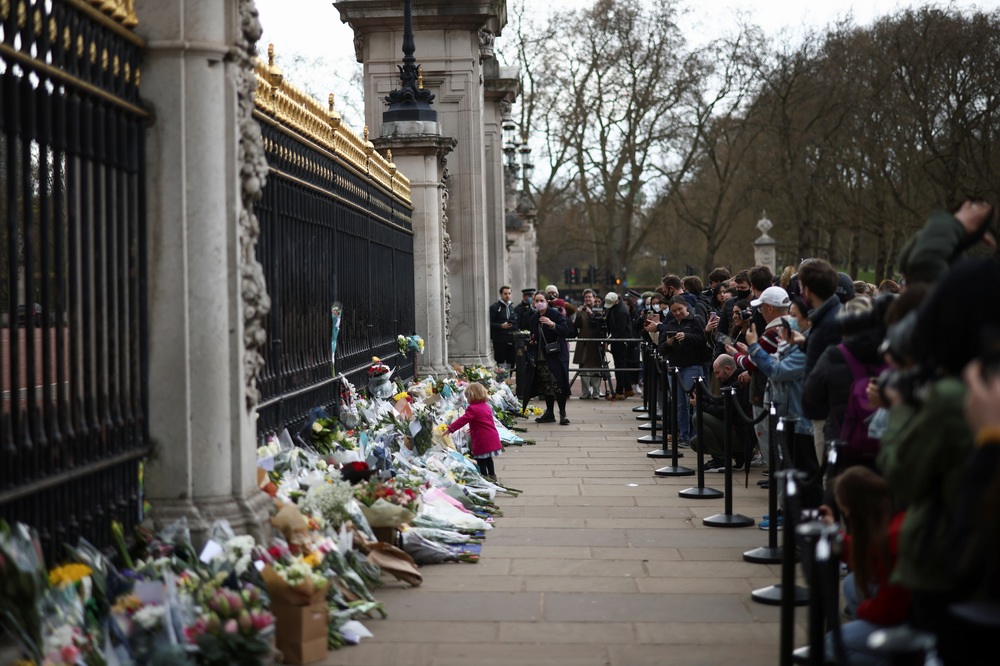 当地时间2021年4月9日，英国民众在伦敦白金汉宫门前摆放鲜花，寄托哀思。