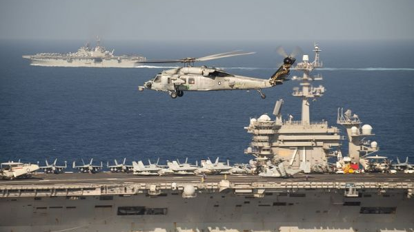 ▲2020年2月15日，一架MH-60S“海鹰”直升机飞行于美军“罗斯福”号航母（中）和“美利坚”号两栖攻击舰身旁穿越太平洋。（美国海军网站）