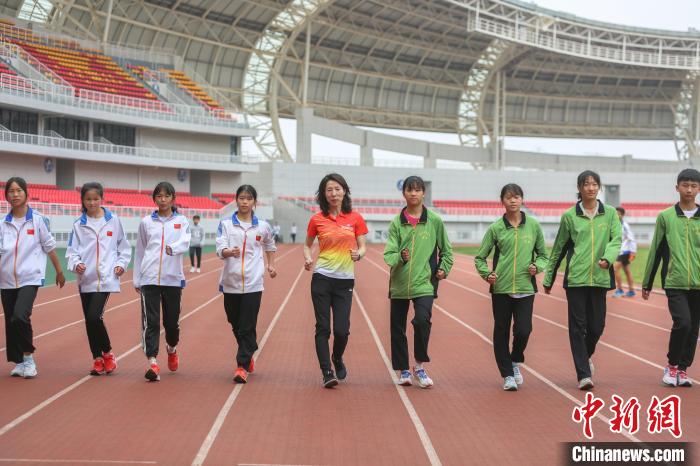 图为世界青年田径锦标赛5公里竞走冠军高红苗和小运动员们一起在田径场上训练。　刘力鑫 摄