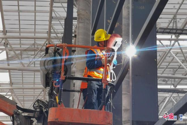 图为施工人员正在焊接航站楼幕墙龙骨