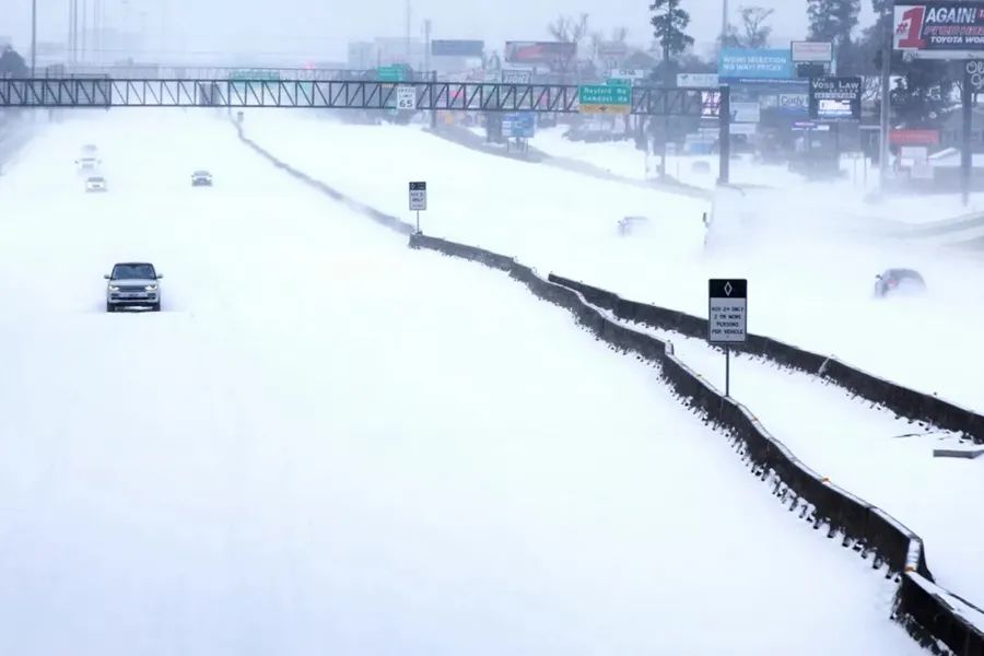  2月15日，汽车行驶在得克萨斯州的雪地里。图源：新华社