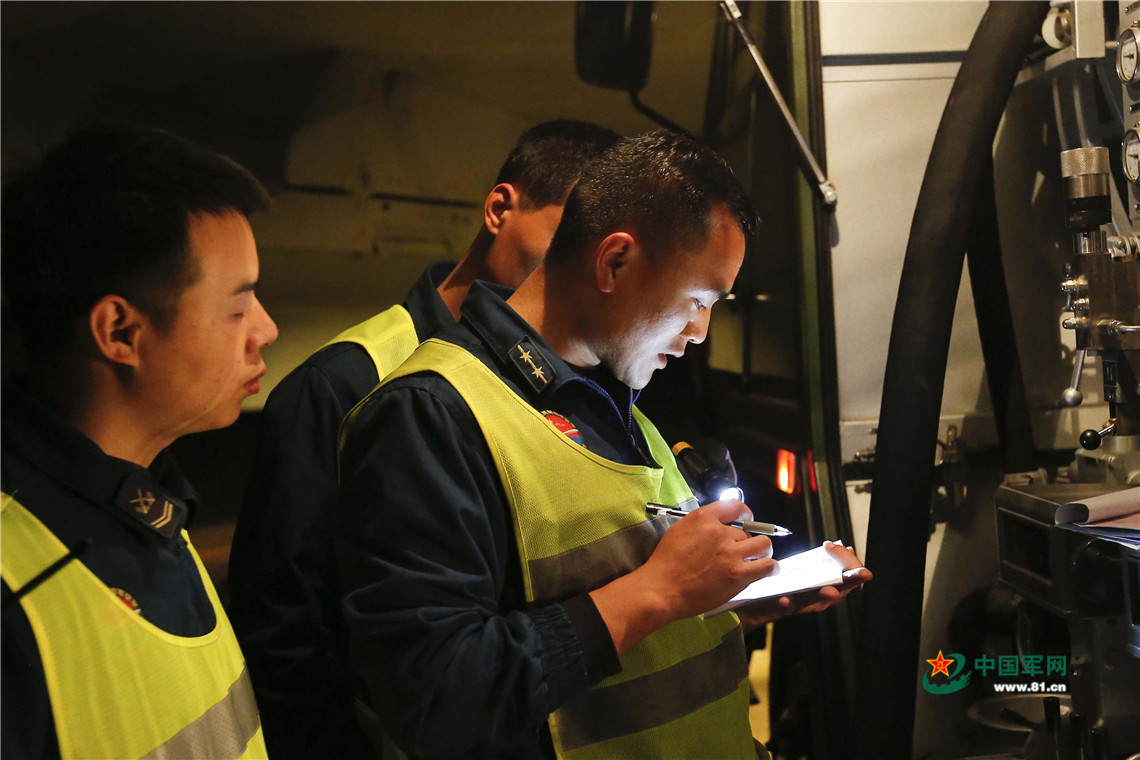 战机在异地机场降落,机务人员检查飞机.王宇龙 摄