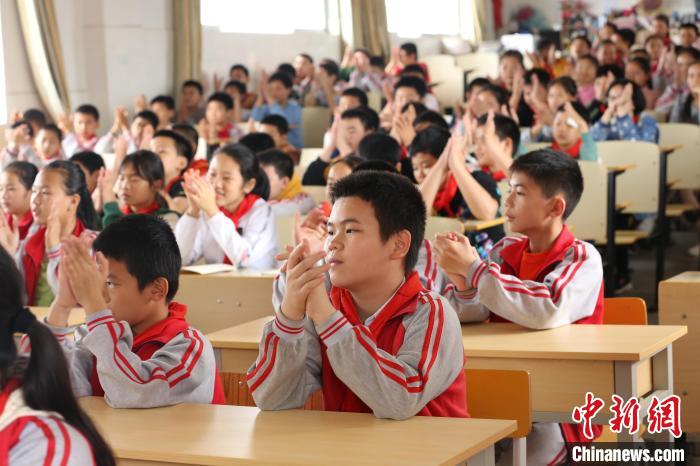 学生们听故事时鼓掌. 朱柳融 摄