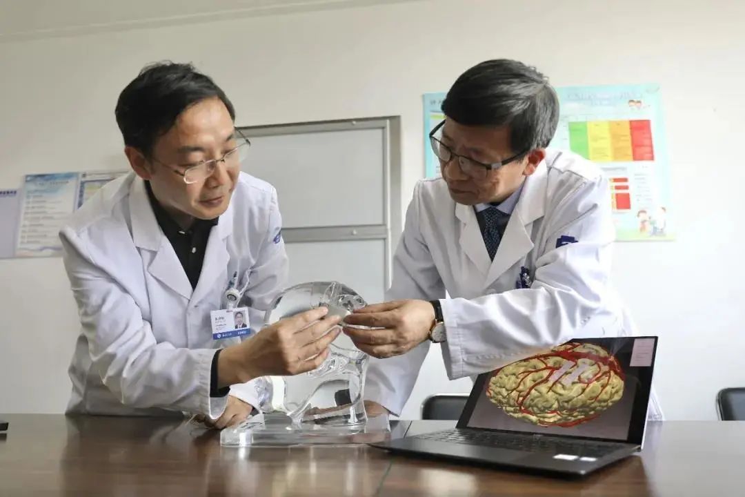 张建民教授（右）和朱君明教授（左）展示电极片安装